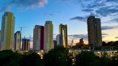 Günbatımında ışıl ışıl parlayan modern şehir siluetinin çarpıcı manzarası canlı mimari ve tasarımı vurguluyor.