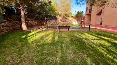 Salıncaklarla dolu sakin bir park, rahat bir bank, ve yemyeşil çimenler, rahatlama ve rahatlama aktiviteleri için mükemmel.