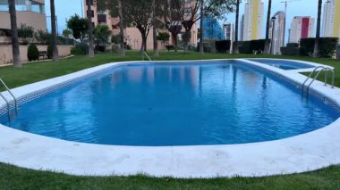 Yeşillik ve modern binalarla çevrili sakin bir havuz. Rahatlamak ve gevşemek için mükemmel.