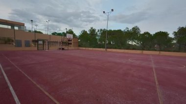 Gelin ve çağdaş bir açık basketbol sahasını keşfedin. Yeşillik ve büyüleyici gökyüzünün ortasında güzelce yerleşmiş.