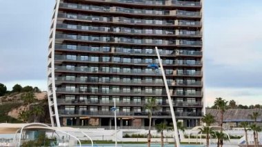 Zarif balkonlarla tamamlanmış, kendine özgü kıvrımlı bir cephe sergileyen etkileyici, modern bir bina.