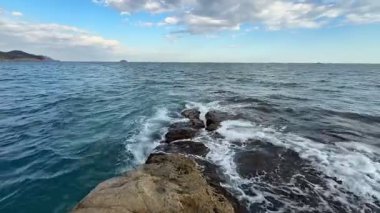 Şaşırtıcı güzellikteki deniz manzarası dalgaların engebeli kayalık oluşumlara çarpmasını gösteriyor.