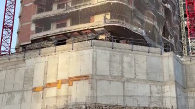 Dinamik görüntüler çeşitli inşaat aşamalarını etkin bir şekilde devam eden vinçler ve yapısal elementlerle gösteriyor