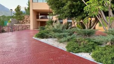 Canlı yeşillik, dekoratif taşlar ve modern elementlerin yer aldığı güzel manzaralı bir patika..