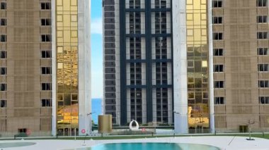 Çarpıcı, karmaşık tasarlanmış modern binalar lüks bir şehir kompleksinin huzurlu havuzuna çok güzel yansıyor.
