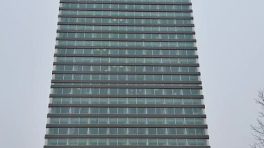 Bu, eşsiz tasarım elementleriyle birlikte çarpıcı bir cam cephe sergileyen gösterişli, modern bir bina.