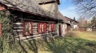 Hoş kırmızı kepenkleri ve güzel yeşil sarmaşıkları olan kırsal ahşap bir evin çarpıcı bir manzarası.