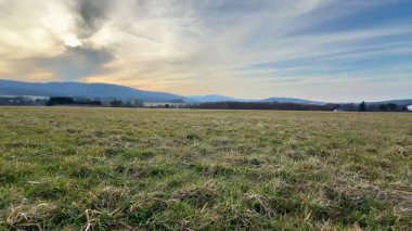 Nefes kesen sakin bir manzara geniş açık araziler ve bulutlu bir gökyüzünün altındaki güzel resimli tepeler.