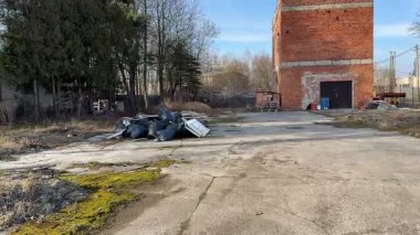 İhmal edilmiş bir çevrede tuğla bina ve enkaz içeren ıssız bir sanayi bölgesi..