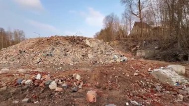 Hareketli bir yıkım alanında, büyük bir enkaz yığını şimdi bulutsuz, berrak bir mavi gökyüzünün altında oturuyor.