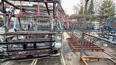 Geniş bir açık hava sanayi bölgesinde bulunan yığılmış metal depolama raflarını gösteren panoramik bir manzara