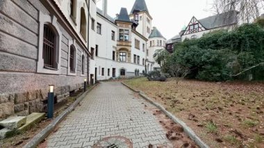 Çevresindeki sakin doğayla kucaklaşan zarif, tarihi bir binanın yanında pitoresk bir yürüyüş yolu.