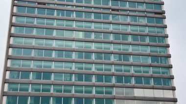 Bu çağdaş ofis binası çarpıcı, parlak cam bir dış görünüme sahiptir.