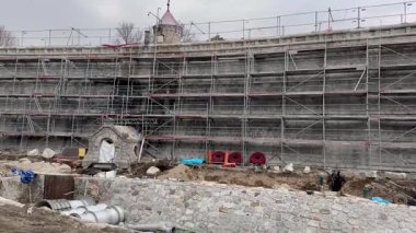 Yapı iskelesi, malzeme ve devam eden çalışma süreçleriyle dolu yoğun bir inşaat alanının görüntüsü