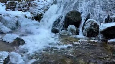 Güzel bir resim gibi donmuş akarsu zarif bir şekilde kayaların üzerinden akıyor, kışların enfes güzelliklerini yakalıyor.