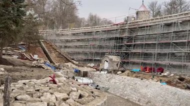 İskele, kazı ve çeşitli yapı malzemeleriyle bir inşaat alanını gösteren detaylı bir manzara.