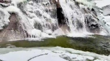 Göz kamaştırıcı, donmuş bir şelale, güzelce karla kaplanmış, doğanın buz gibi güzelliğini ve dingin sükunetini sergiliyor.