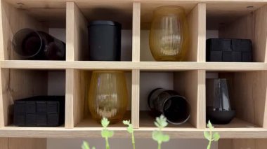 Güzel ekran, ahşap bir rafa düzgünce yerleştirilmiş çeşitli cam ve kaplar içeriyor.