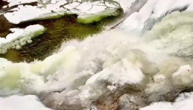 Sakin bir kış ortamında sersemletici bir su manzarası zarif bir şekilde buzlu oluşumların üzerine dökülüyor.