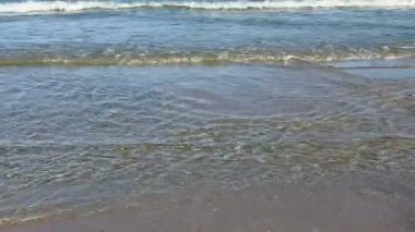 Güzel okyanus dalgaları yumuşak kumlu sahili nazikçe okşayıp mükemmel bir kıyı manzarası yaratıyor.