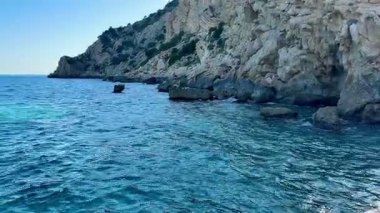 Büyüleyici okyanus manzarası, el değmemiş turkuaz suları ve engin, parlak gökyüzünün altındaki manzaralı uçurumları gösteriyor.