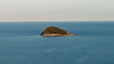 Huzurlu ve huzurlu sularla çevrili büyüleyici ve pitoresk bir ada, huzurlu bir sahil manzarası yakalar.