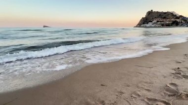 Gerçekten huzurlu bir plaj sahnesi hayal edin, sakin dalgalar, alacakaranlıkta nefes kesici bir günbatımı ile buluşuyor.