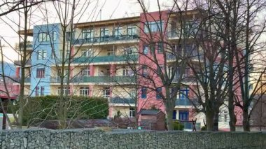 Yeşillik ağaçlarının arasında büyüleyici, renkli bir bina, çarpıcı modern mimari ve kalıcı dinginlik.