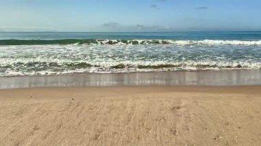 Yumuşak deniz kumlu bir sahilde rahatlatıcı dalgalar. Yüksek kalite 4k görüntü