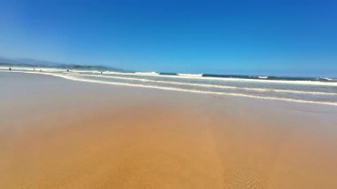 Resmedilmeye değer ve sakin bir sahil sahnesi. Nazik dalgalar, kristal berrak gökyüzü ve yumuşak altın kum.