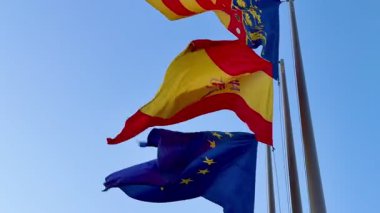 İspanya, Katalonya ve AB 'yi temsil eden renkli ve canlı bayraklar yumuşak meltemde zarifçe dalgalanıyor