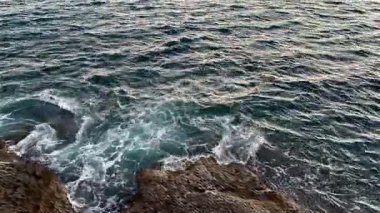 Gelin ve okyanus dalgaları tarafından çarpıcı bir günbatımının eşsiz sükunetini ve güzelliğini yaşayın.