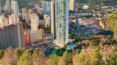 Çarpıcı hava manzarası, enerji ve yaşamla dolu canlı bir şehir içinde modern gökdelenleri gösteriyor.