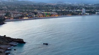 Sakin ve sakin bir deniz manzarası sergiliyor sakin, parlak sular ve çarpıcı bir günbatımı manzarası.