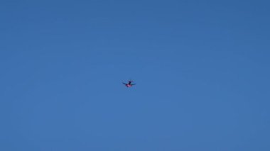 Görkemli bir jet, zarif bir şekilde açık mavi gökyüzünde süzülüyor, havacılığın gücünü simgeliyor.