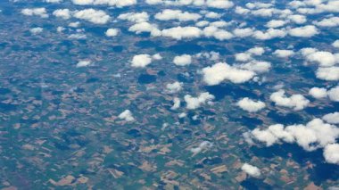 Nefes kesici bir hava görüntüsü canlı, renkli tarlaları ve yukarıdan gelen yumuşak, tüylü bulutları güzel bir şekilde gösteriyor.