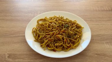 Renkli taze sebzelerle süslenmiş baharatlı erişte kasesinin tadını çıkarın. Hızlı ve doyurucu yemekler için mükemmeldir.