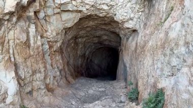 Terk edilmiş bir tünelin saklı harikalarını keşfedin kayalık arazide, canlı yemyeşil ile çevrili