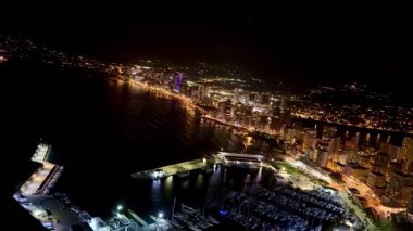 Göz kamaştırıcı bir hava manzarası canlı şehir siluetini ve parıldayan sahil gece hayatını yakalar.