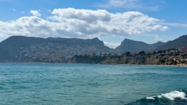 Temiz su, görkemli dağlar ve dinginlik ve seyahat için ideal, canlı bir gökyüzü ile güzel bir kıyı şeridi.