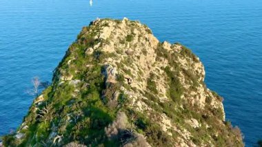 Serin bir okyanus zeminine karşı yemyeşil yemyeşil bir kayalık adanın nefes kesici hava manzarası