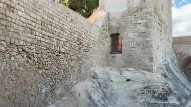 Göz kamaştırıcı resimli taş bir kule. Eski duvarların arasında güzelce yerleştirilmiş ve canlı yeşilliklerle çevrili.