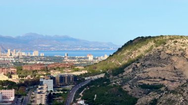Büyüleyici bir manzara, heybetli dağlara ve sakin bir deniz zeminine yuva yapmış canlı bir şehir sergiliyor.