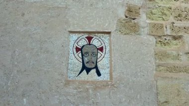Çok güzel tasarlanmış tarihi bir mozaiğin, antik bir duvarda önemli bir şahsiyeti gösteren yakın çekimi.