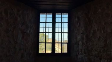 Büyüleyici, kırsal taş pencere çerçevelerinin ardında, doğanın ihtişamını güzel bir şekilde gösteren pitoresk bir manzara.
