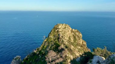 Durgun denizlerin yanında, berrak, parlak mavi gökyüzünün altında yükselen uçurumların çarpıcı güzelliğini hissedin.