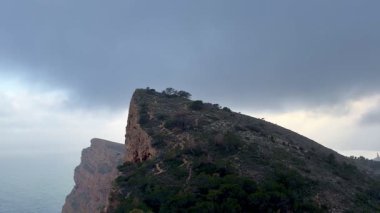 Karamsar bir gökyüzü ve denizin yanında yemyeşil, engebeli uçurumlar sergilenen kesinlikle çarpıcı bir manzara.