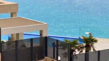 Okyanusa bakan, sallanan palmiye ağaçları ile güçlendirilmiş büyüleyici sonsuz havuzu olan güzel bir manzara.