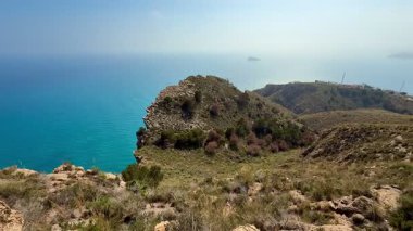 Bir tepeden, soluk kesici manzaranın tadını çıkarın. Huzurlu mavi denizi ve yemyeşil yeşilliği her yerde sergiliyor.