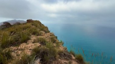 Bulutlu gökyüzünün altındaki dingin, masmavi okyanusla birlikte nefes kesen dramatik sahil uçurumlarını keşfetmeye cesaret edin.